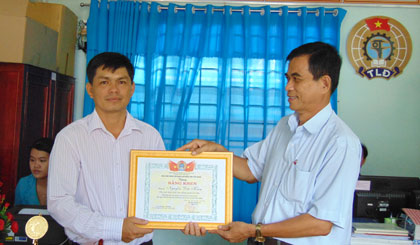  Ông Trương Văn Hiền, Chủ tịch Liên đoàn Lao động tỉnh Tiền Giang trao thưởng đột xuất cho anh Nguyễn Đức Kiên (người đứng bên trái).   