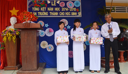 Thầy Nguyễn Văn Khai, Hiệu trưởng nhà trường trao thưởng cho 3 em học sinh xuất sắc nhất của 3 khối lớp.