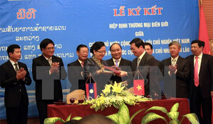 Bộ trưởng Bộ Công Thương Việt Nam Vũ Huy Hoàng và Bộ trưởng Bộ Công Thương Lào Khemmani Pholsena ký Hiệp định. Ảnh: Tá Chuyên/TTXVN