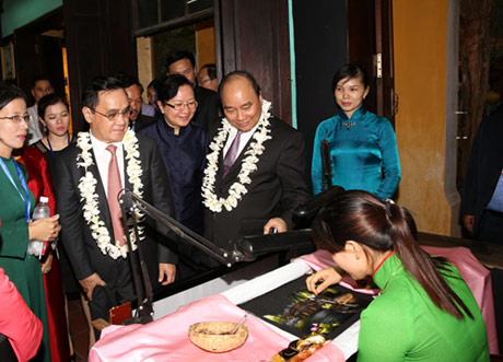 Phó Thủ tướng Nguyễn Xuân Phúc, Thủ tướng Lào Thongsing Thammavong thăm gian hàng tranh thêu nghệ XQ tại Hội An - Ảnh: VGP/Lê Sơn