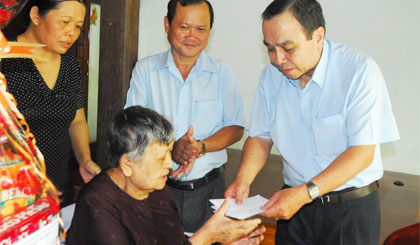 Ông Nguyễn Hữu Đức, Tổng Biên tập Báo Ấp Bắc thay mặt đoàn thăm hỏi, động viên và tặng quà bà Nguyễn Thị Bảy, là vợ liệt sĩ.