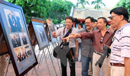 Các nhiếp ảnh gia và du khách xem triển lãm “Quan hệ Việt-Mỹ và nước Mỹ qua ống kính nhà nhiếp ảnh Việt Nam.” Ảnh: An Đăng/TTXVN