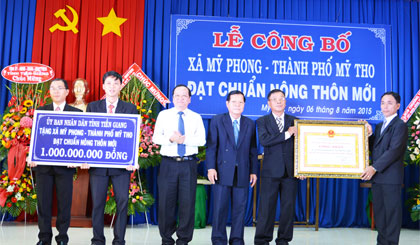 Chủ tịch UBND tỉnh Nguyễn Văn Khang và Phó Chủ tịch UBND tỉnh Trần Thanh Đức trao Bằng Công nhận và tặng công trình phúc lợi trị giá 1 tỷ đồng của UBND tỉnh cho xã đạt chuẩn NTM Mỹ Phong.