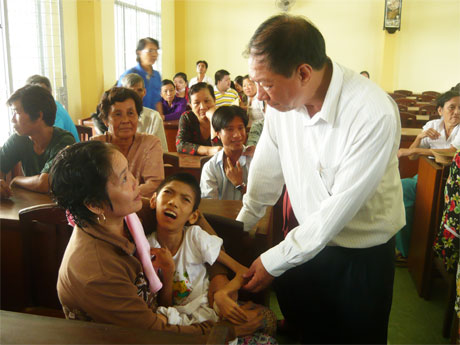 Ông Lê Quốc Bảo, Chủ tịch Hội Nạn nhân chất độc da cam tỉnh thăm hỏi nạn nhân da cam trong ngày họp mặt, phát quà 4-8-2015. 					                           Ảnh: N.T
