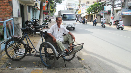Ông Nguyễn Minh Tính cùng chiếc xích lô đạp cũ kỹ.