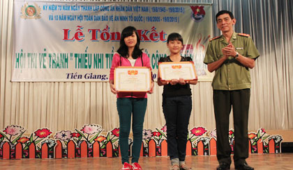 Đại tá Nguyễn Hữu Trí, Phó Giám đốc Công an tỉnh trao giải A cho 2 em.