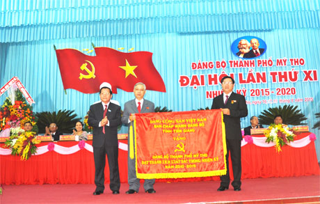 Phó Bí thư Tỉnh ủy, Chủ tịch UBND tỉnh Nguyễn Văn Khang trao Cờ của BCH Đảng bộ tỉnh tặng Đảng bộ TP. Mỹ Tho.