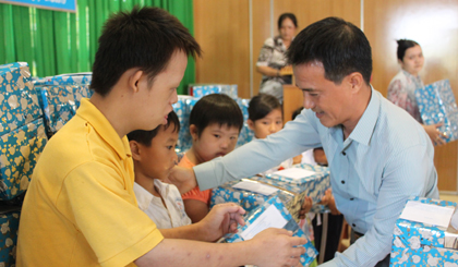 Ông Nguyễn Thanh Lâm, Giám đốc Công ty TNHH TMKT Thanh Lâm trao quà cho các em