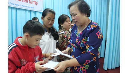 Bà Nguyễn Thị Ánh, Giám đốc Công ty cổ phần Thủy sản Sông Tiền trao quà cho các em.
