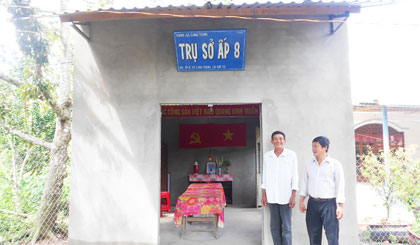 Ông Nguyễn Văn Trung (bên trái) trước  trụ sở ấp xây dựng hoàn thành trong năm 2014.
