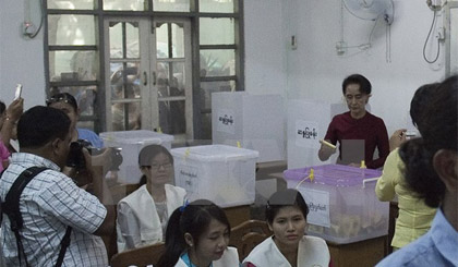 Bà Aung San Suu Kyi (phải), người đứng đầu Liên minh quốc gia vì dân chủ (NLD) đối lập bỏ phiếu tại điểm bầu cử ở Yangon ngày 8/11. Ảnh: AFP/TTXVN