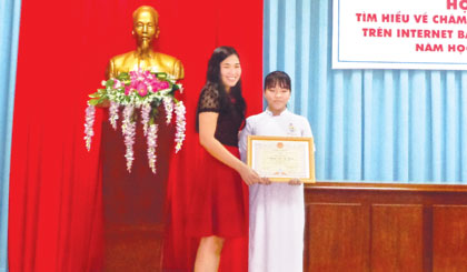 Bà Phan Thị Trang, cán bộ Quản lý dự án của FHF trao giải Nhất cho thí sinh Nguyễn Quốc An Khang (Trường THCS Tân Mỹ Chánh, TP. Mỹ Tho).