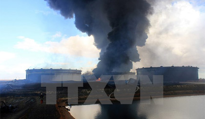 Khói bốc lên từ một kho dự trữ dầu tại nhà máy lọc dầu ở Ras Lanouf, Lybia ngày 23/1 sau các cuộc tấn công của IS. Nguồn: AFP/TTXVN