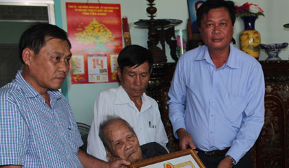 Ông Nguyễn Trong Hữu (phải), Phó Bí thư Thường trực Thành ủy  đến dự trao Huy hiệu 70 năm tuổi Đảng cho đảng viên Nguyễn Thành Sơn