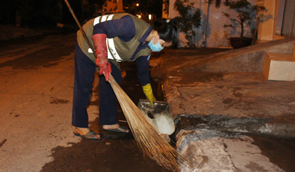 Chị Trương Thị Mỹ Dung đang thu gom rác trên đường.