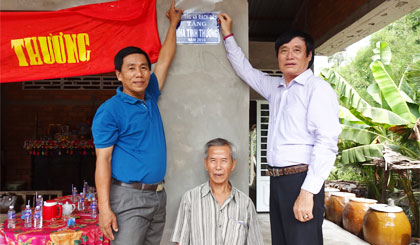 Anh Trần Đỗ Liêm (bên phải) bàn giao nhà tình thương tại  huyện Cái Bè.