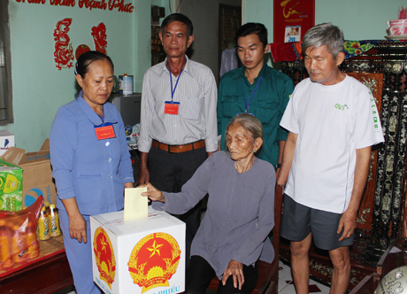 Tổ bầu cử số 1, ấp Phong Thuận, xã Tân Mỹ Chánh, TP. Mỹ Tho  mang thùng phiếu phụ đến hộ bà Nguyễn Thị Hoa (91 tuổi).