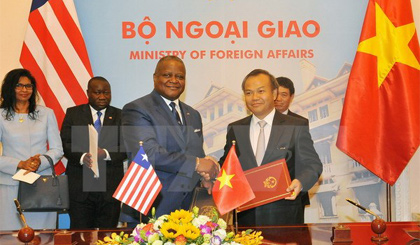 Thứ trưởng Ngoại giao Vũ Hồng Nam và Đại sứ Liberia tại Trung Quốc D.McKinley Thomas ký thông cáo thiết lập quan hệ ngoại giao Việt Nam-Liberia. (Ảnh: Nguyễn Khang/TTXVN)
