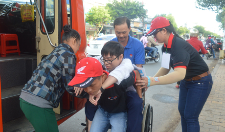 Các bạn SV tình nguyện hỗ trợ em Phước Chung, trường THPT Gò Công Đông. xuống xe để vào phòng thi.