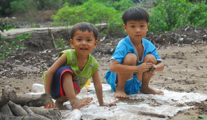 Anh em ruột Trần Tuấn Tài (5 tuổi) và Trần Tài Gia Thuận (3 tuổi) ở xã Mỹ Phước Tây, TX. Cai Lậy đùa giỡn với cát trong những ngày hè.
