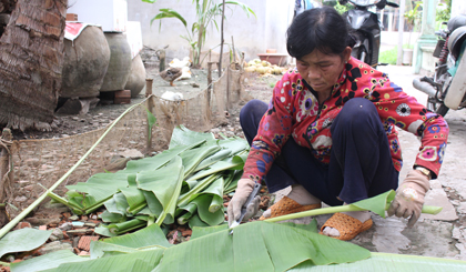 Cô Nguyễn Thị Kim Hoa đang rọc lá chuối ra để bó lại.