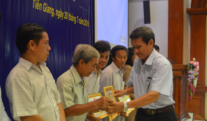 Ông Nguyễn Trung Trí, Phó Giám đốc công ty điện lực trao bằng khen cho các hộ gia đình.