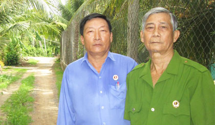 Thương binh Lê Văn Hai (bên trái) vận động CCB Lê Văn Mười hiến 180 m2 đất xây dựng đường giao thông nông thôn.