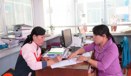 Chị Trần Thị Thanh Tâm (bên phải) hướng dẫn người dân làm giấy khai sinh.
