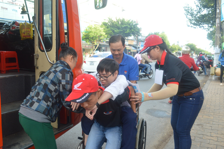 Phước Chung, học lớp 12, Trường THPT Gò Công Đông được TNTN Trường Đại học Tiền Giang cõng xuống từ trên xe để tham dự kỳ thi THPT Quốc gia 2016.