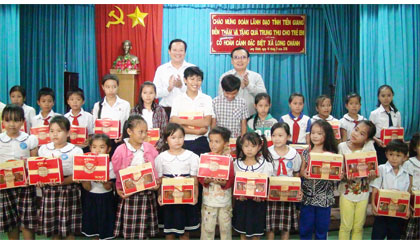 Ông Võ Văn Bình, Phó Bí thư Tỉnh ủy (bên phải) tặng quà trung thu cho trẻ em có hoàn cảnh khó khăn xã Long Chánh, TX. Gò Công.