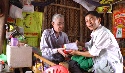 Ông Nguyễn Thanh Tâm nhận tiền, quà do phóng viên  Đài Truyền thanh - Truyền hình huyện Tân Phú Đông trao. 
