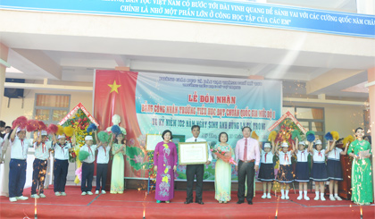 Bà Trần Thị Quý Mão, Phó Giám đốc Sở GD-ĐT và ông Đặng Thanh Liêm, Bí thư Thành ủy Mỹ Tho trao Bằng công nhận “Trường đạt chuẩn Quốc gia mức độ 1” cho nhà trường.