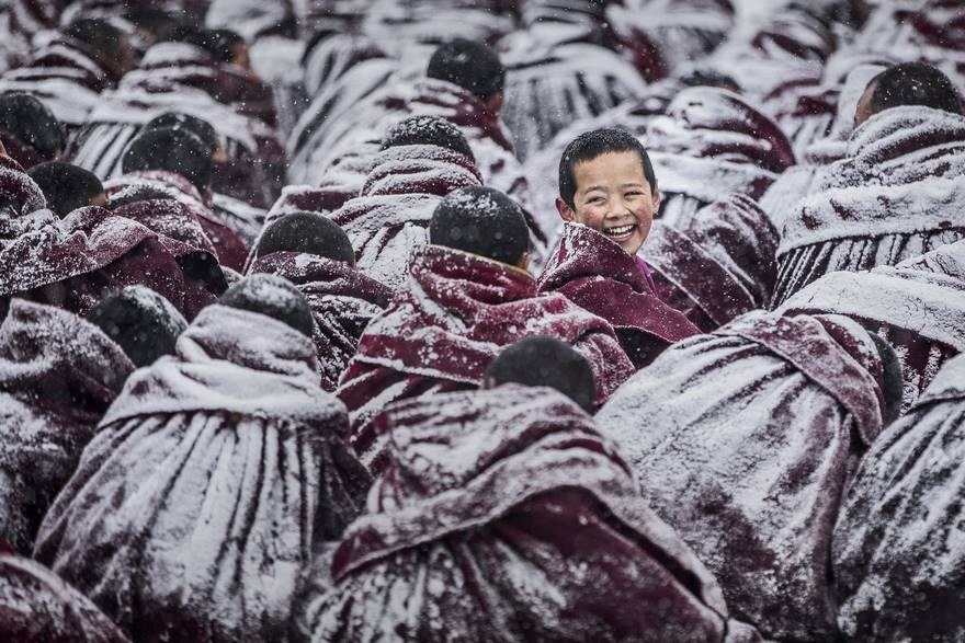 Nụ cười - Hạng mục ảnh chân dung: Hội Phật giáo ở Tây Tạng, do tuyết rơi dày nên áo của các lạt ma bị bao phủ bởi lớp tuyết trắng xóa. Một lạt ma quay đầu cười tươi. (Nguồn: boredpanda)