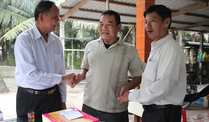 Trung tướng Nguyễn Việt Thành (bên trái) thăm hỏi và tặng quà nông dân Nguyễn Văn Thêm