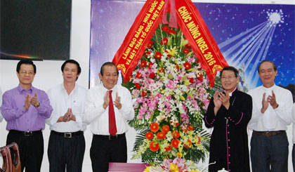 Deputy Prime Minister Truong Hoa Binh presents flowers to the bishop of My Tho  Nguyen Van Kham.