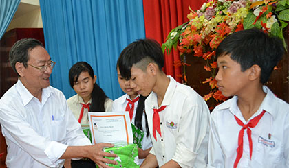 ông Phan Văn Hà, Chủ tịch Hội bảo trợ bệnh nhân nghèo- người khuyết tật và trẻ mồ côi tỉnh trao học bổng cho các em học sinh tại lễ trao học bổng