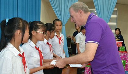 ; ông Scott Hodgetts, Tổng Giám đốc khách sạn Sheraton Sài Gòn trao học bổng cho các em học sinh tại lễ trao học bổng