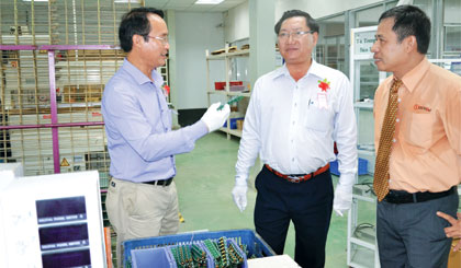 Ông Lưu Văn Phi (trái), Giám đốc Sở Ngoại vụ và ông Đặng Thanh Liêm, Bí thư Thành ủy Mỹ Tho  tham quan dây chuyền sản xuất của Công ty TNHH Công nghiệp và Thiết bị chiếu sáng Duhal.