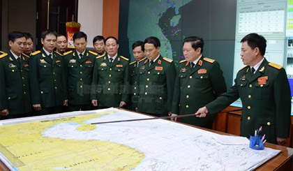 Bộ trưởng Ngô Xuân Lịch nghe kíp trực SSCĐ tại Sở chỉ huy K2000 báo cáo tình hình.  