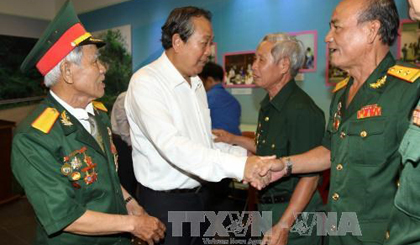 Deputy PM Truong Hoa Binh (in white) shakes hand with a veteran revolutionist. (Source: VNA)