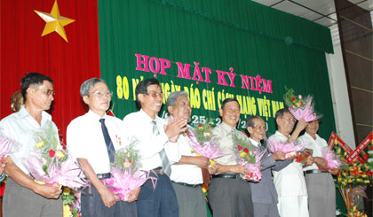 Nhà báo Trần Bửu (thứ hai từ trái sang) được tặng hoa nhân Họp mặt kỷ niệm 80 năm Ngày Báo chí cách mạng Việt Nam.