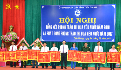 Ông Huỳnh Văn Bé Hai (bìa phải), nhận Cờ thi đua năm 2016 của UBND tỉnh. 