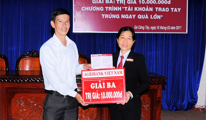 Bà Phan Thanh Hương, Giám đốc Agribank huyện Gò Công Tây  trao thưởng cho khách hàng may mắn Nguyễn Thanh Khoa.