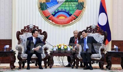 Lao Prime Minister Thongloun Sisoulith (R) receives Vietnamese Finance Minister Dinh Tien Dung on March 30 (Photo: VNA)