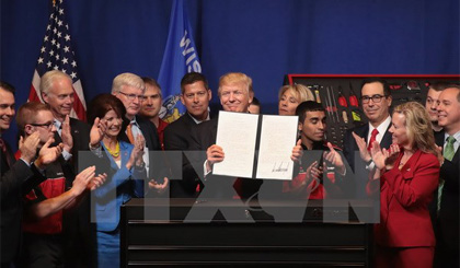 Tổng thống Donald Trump (giữa, phía trước) ký sắc lệnh hành pháp về việc tăng cường và xem xét chương trình thị thực H-1B. Nguồn: AFP/TTXVN
