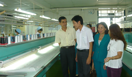Ông Trương Văn Hiền (bìa trái) thăm hỏi công nhân, lao động đang trực tiếp làm việc tại xưởng sản xuất của một doanh nghiệp.