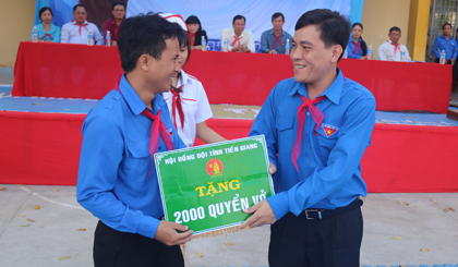 Anh Ngô Huỳnh Quang Thái (bên phải) trao Bảng tượng trưng tặng 2.000 quyển tập cho Trường THCS Thạnh Trị (huyện Gò Công Tây) trong Ngày hội “Tuổi trẻ Tiền Giang rèn luyện thân thể theo gương Bác Hồ vĩ đại” năm 2017.