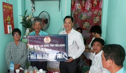 Ông Lưu Nhơn Đức, Chủ tịch CĐGD tỉnh Tiền Giang trao biểu trưng Mái ấn Công đoàn cho ông Huỳnh Văn Giỏi.