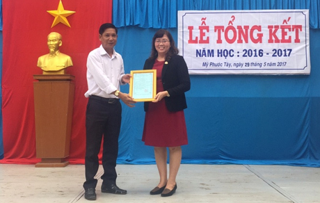Ông Nguyễn Văn Thảo, Chủ tịch UBND xã Mỹ Phước Tây trao thư cảm ơn cho nhà tài trợ.