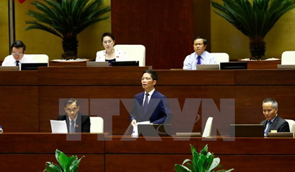 Minister of Indusry and Trade Tran Tuan Anh (standing) ​explains issues related to the bill at the session (Photo: VNA)